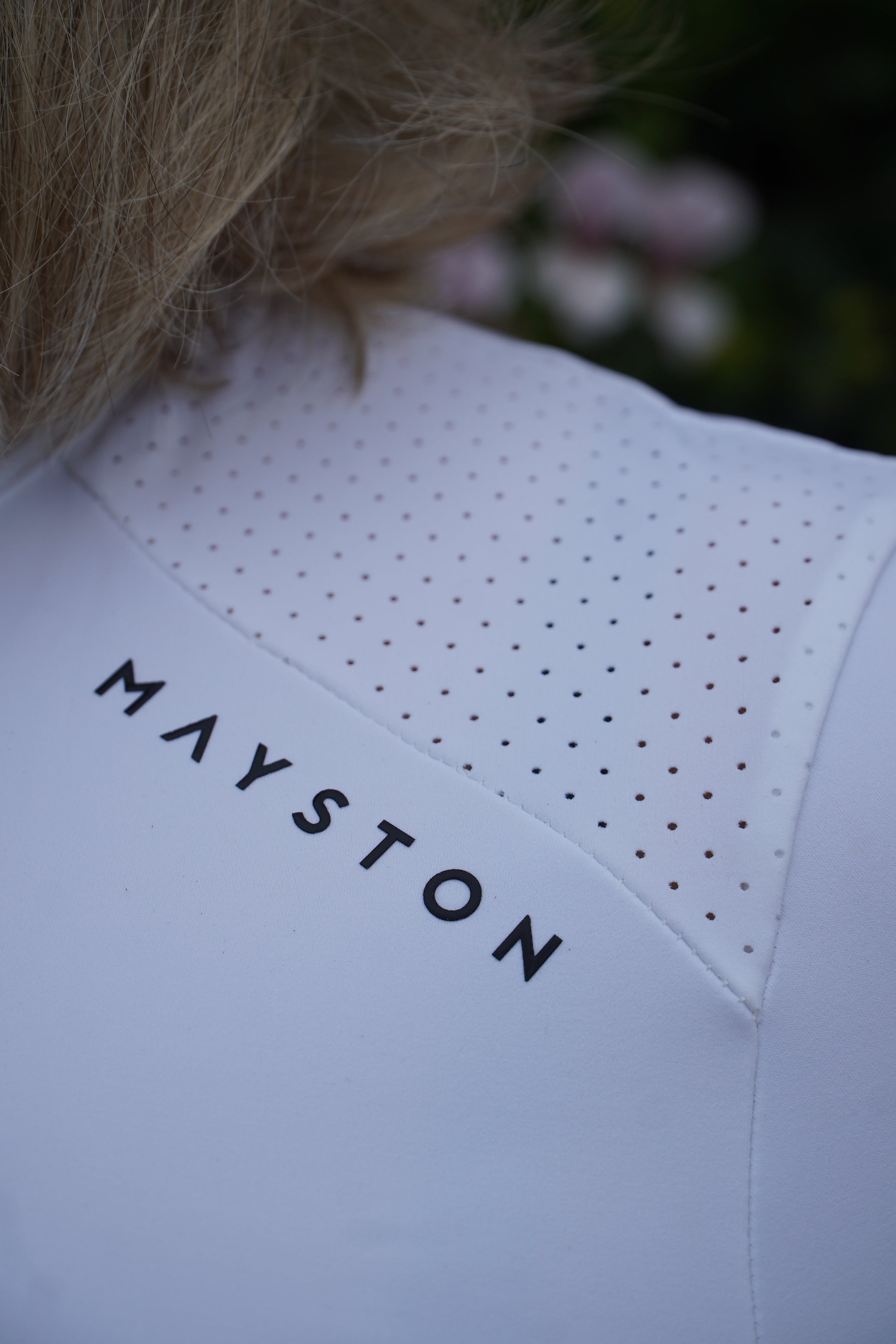 White Base Layer with 'MAYSTON' branding on a blurred background. Sleek silhouette baselayer showshirt top subtle Mayston branding, maximum coverage without compromising style, next-level performance with a bold, minimalist look. Moisture-wicking, breathable fabric with four-way stretch, it keeps you cool and comfortable. Training, Everyday or competition wear. long sleeve Sleeve 1/4 zip with standup collar. Suble Black Mayston branding.