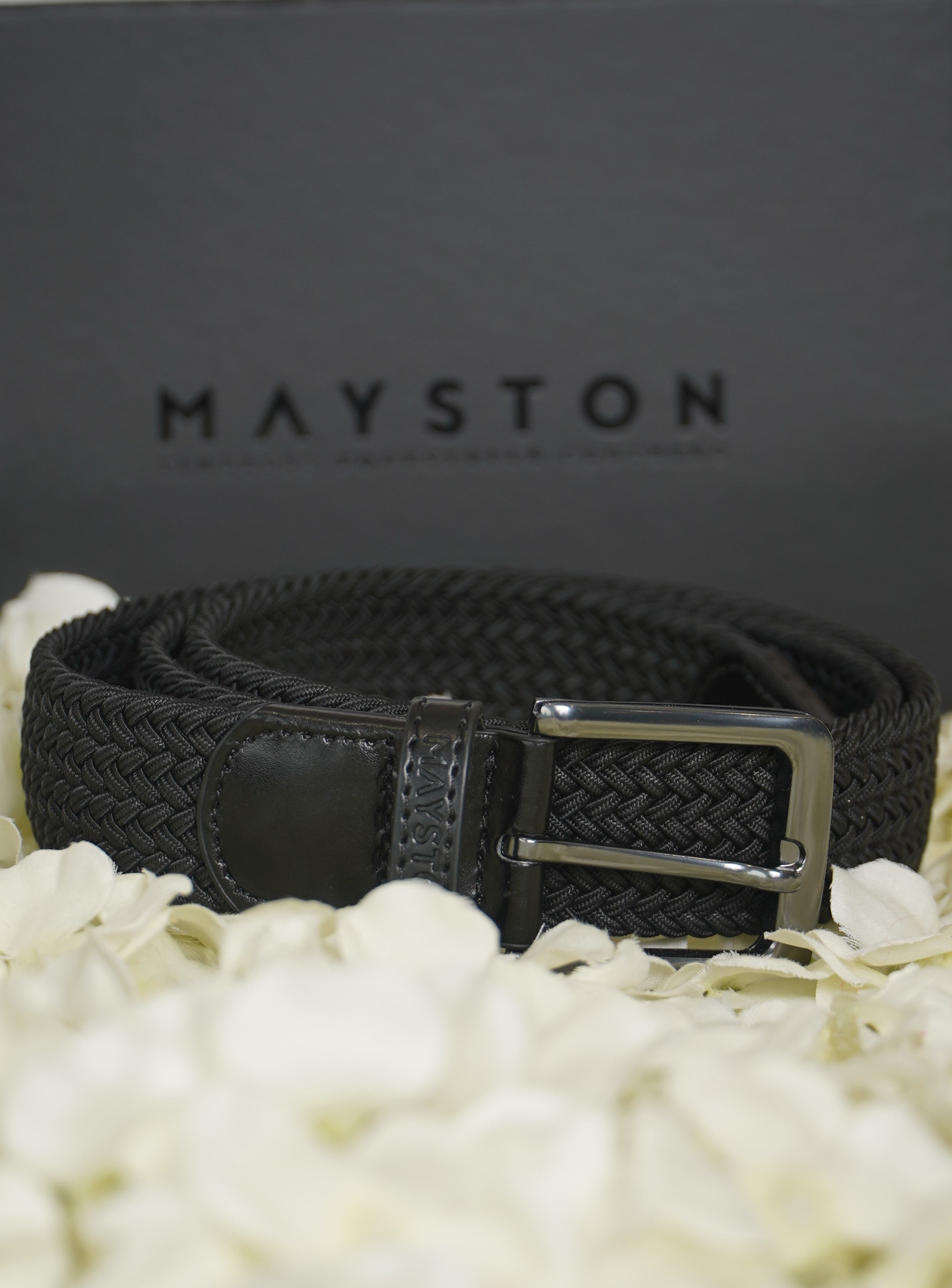 Black Elastic woven belt with silver buckle on a white floral background with Mayston branding.