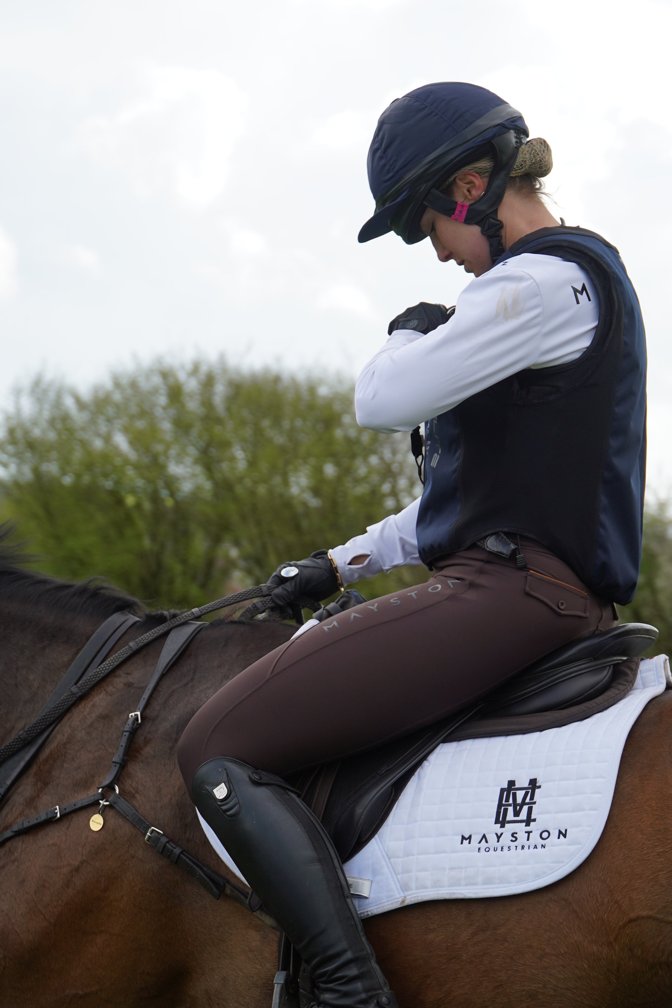 Premium breeches with a Full Silicone seat. Stretch high waisted Jodhpurs. Deep pockets, supportive, comfortable and compression quality fabric. Elegant detailing with subtle branding. dark brown chocolate. Person cross country training schooling jumping