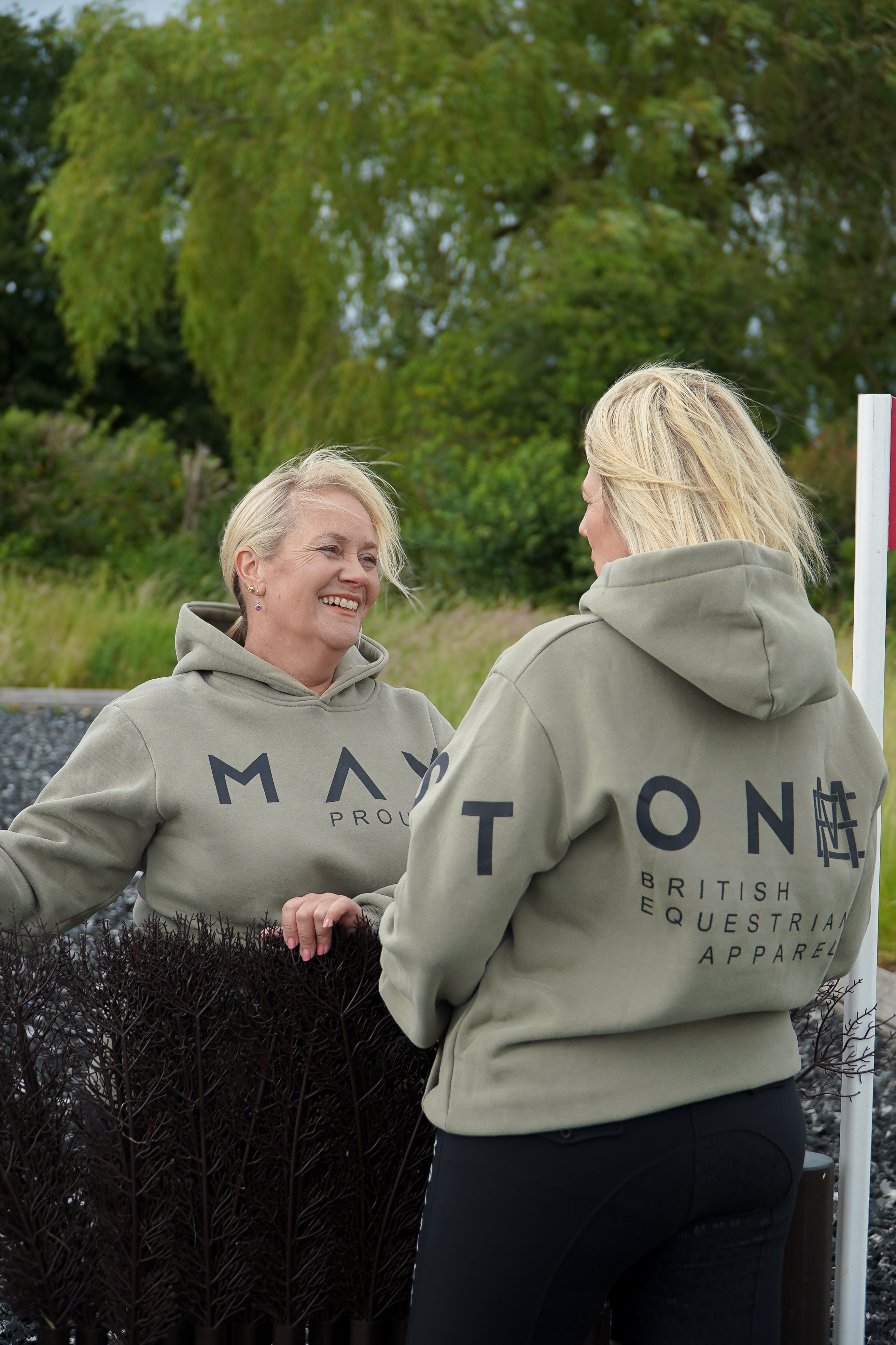 Two women wearing matching green hoodies with branding in an outdoor setting. A person wearing a green hoodie with a large hood, standing next to a white horse. The person is wearing black pants and black boots, and the hoodie has the word 'Equestrian' written on it.
High quality luxurious 100% cotton. wrap around bold logo. soft, cozy and warm. Hoodie, jumper sweatshirt. everyday wear. casual and smart