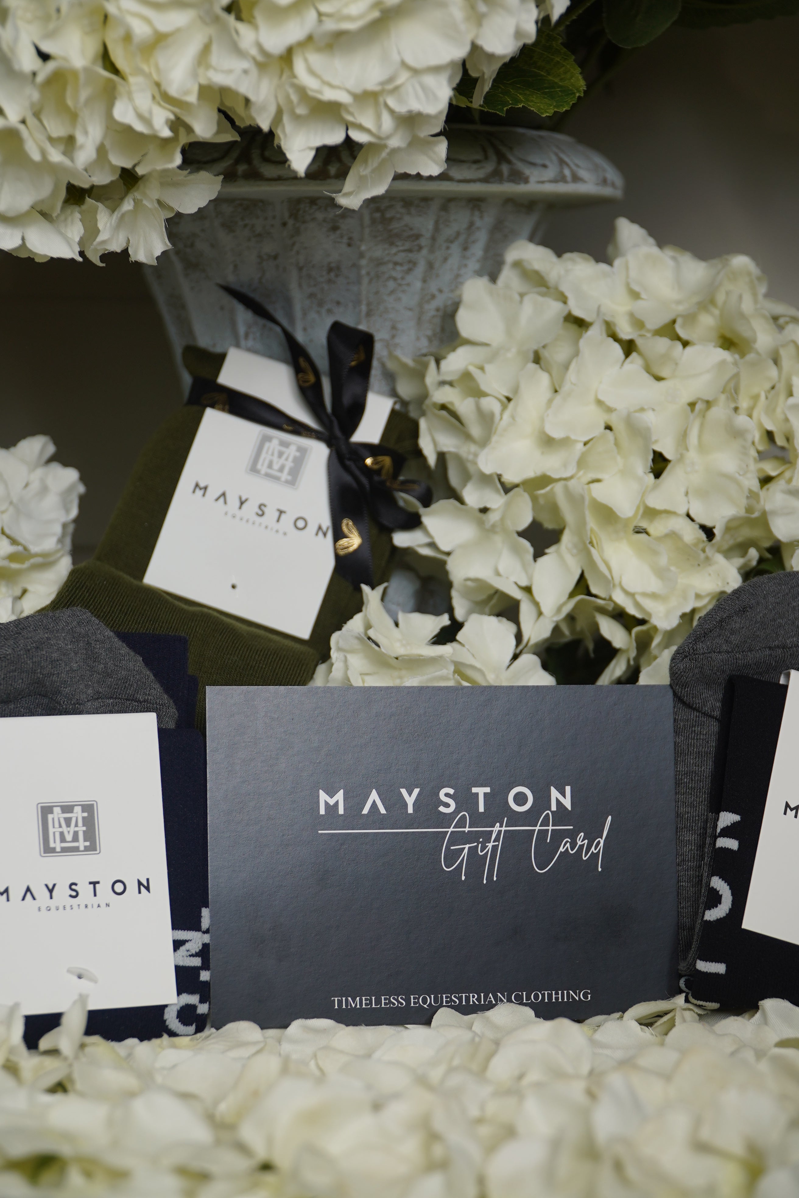 Mayston product packaging with white flowers in the background. gift card for equestrian clothing