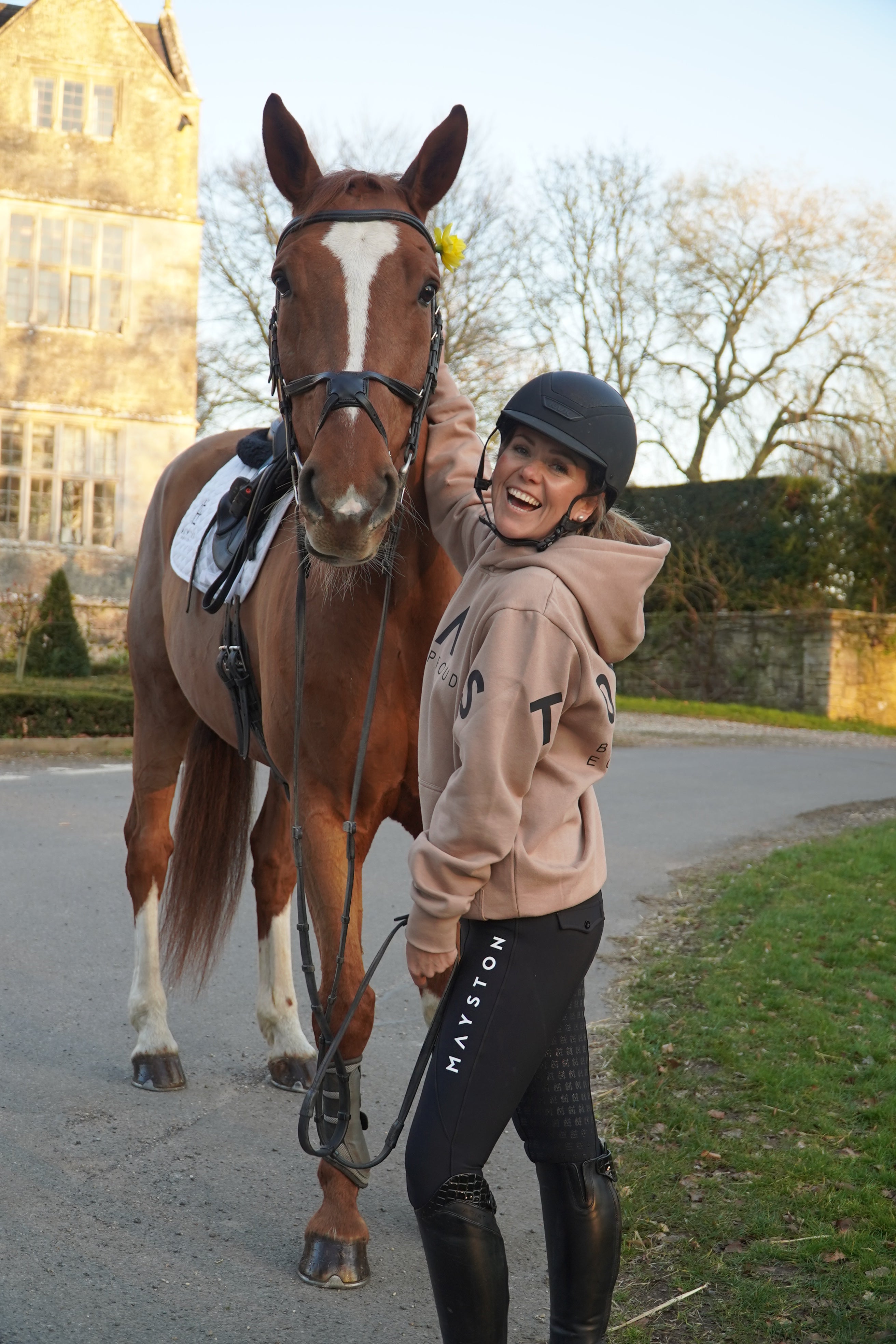 Person in equestrian attire with two horses on a path. Brown beige and black hoodie
High quality luxurious 100% cotton. wrap around bold logo. soft, cozy and  warm. Hoodie, jumper sweatshirt. everyday wear. casual and smart